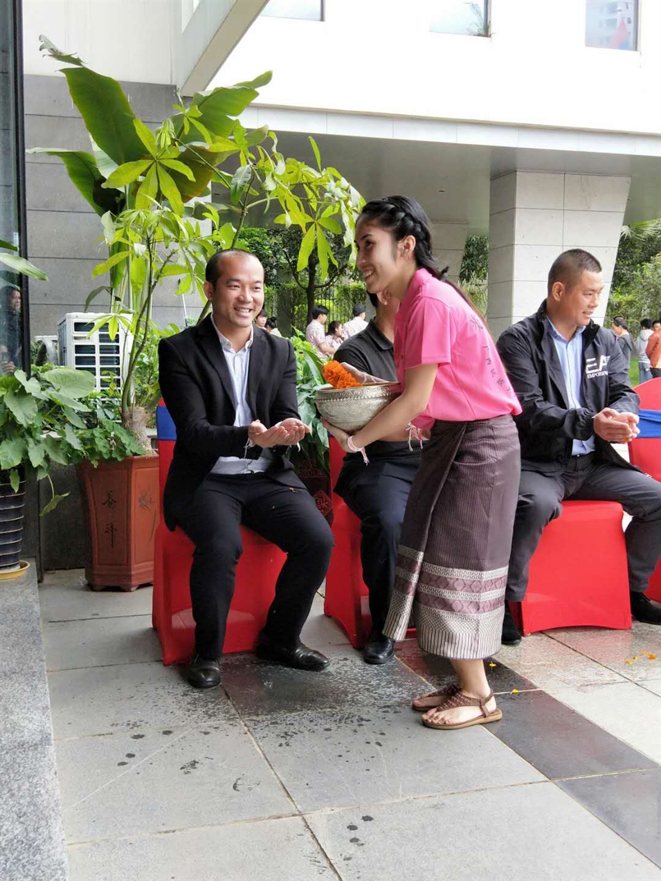 老撾駐廣西留學(xué)生代表將浸有花瓣的香水灑客人的手上，表示對(duì)嘉賓的美好祝福（圖一）