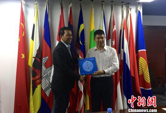 中國—東盟博覽會秘書處副秘書長黃平西（右）與柬埔寨新聞部新聞與傳播總司副總司長春占皮侖（左）互贈禮物。