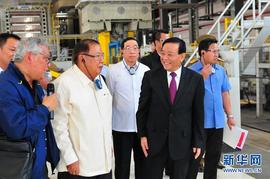 3月10日，在老撾沙灣拿吉省車邦縣，老撾人民革命黨中央總書記、國(guó)家主席本揚(yáng)（左二）在山東太陽(yáng)紙業(yè)股份有限公司董事長(zhǎng)李洪信（右二）的陪同下視察公司。 新華社記者章建華攝